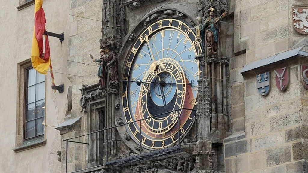 Prague Astronomical Clock on the Old Town Hall tower overlooking Old Town Square with visitors gathered below.